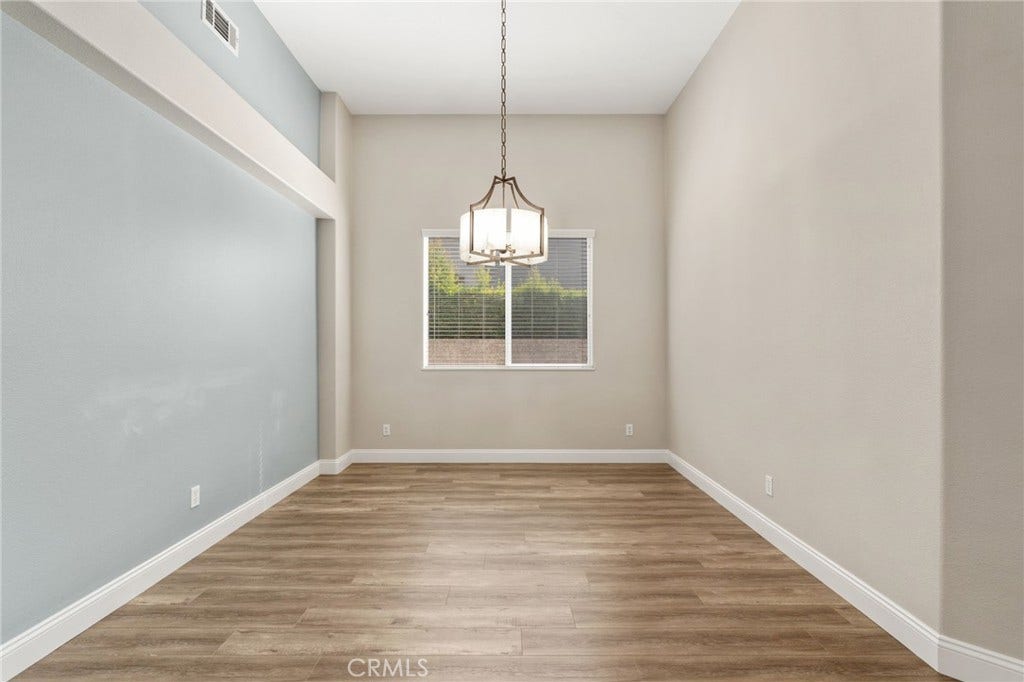 32440 Magenta Court, Temecula, CA 92592 Elegant Formal Dining Room Featuring Soaring Ceilings, An Attractive Light Fixture, Wood-Look Flooring, And A Large Window Providing Natural Light.