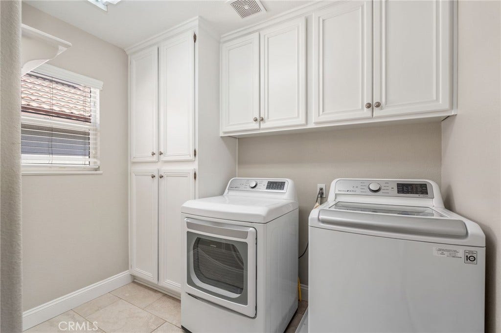32440 Magenta Court, Temecula, CA 92592 Convenient Indoor Laundry Room Featuring A Side-By-Side Washer And Dryer, Abundant Built-In Cabinetry For Storage, Tile Flooring, And A Window Providing Natural Light.