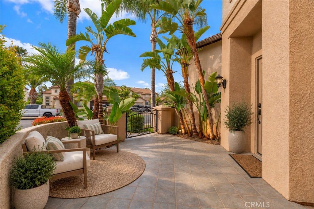 32440 Magenta Court, Temecula, CA 92592 Inviting Front Courtyard Featuring A Spacious Paved Patio, Tropical Landscaping, And A Peaceful Setting For Outdoor Relaxation. Digitally Staged