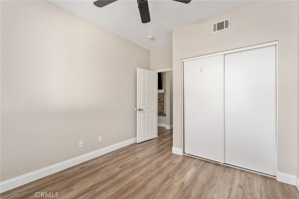 32440 Magenta Court, Temecula, CA 92592 Another View Of The Bedroom Highlighting The Spacious Layout, Sliding-Door Closet, Ceiling Fan, And Attractive Wood-Look Flooring.