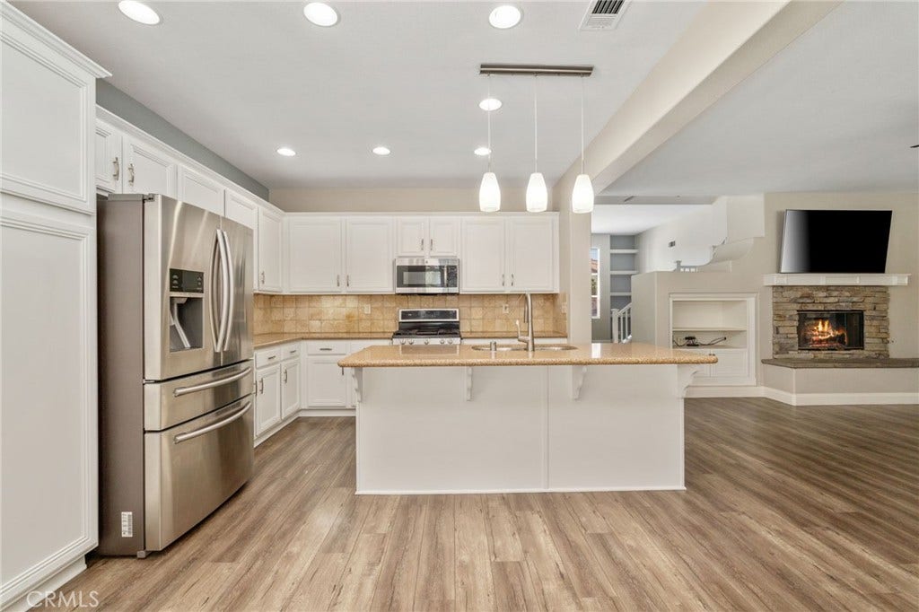 32440 Magenta Court, Temecula, CA 92592 Spacious Open-Concept Kitchen Featuring A Large Center Island With Breakfast Bar, Stainless Steel Appliances, Recessed Lighting, And A Beautiful View Into The Family Room With Stone-Surround Fireplace.