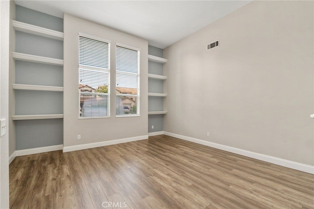 32440 Magenta Court, Temecula, CA 92592 Spacious And Versatile Front Room Featuring Built-In Shelving, Large Windows, And Wood-Look Flooring, Offering Endless Possibilities For A Home Office, Sitting Room, Or Additional Living Area.