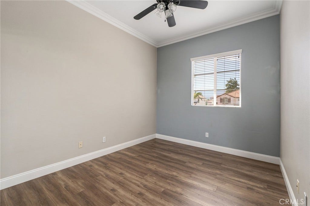 32440 Magenta Court, Temecula, CA 92592 Spacious Secondary Bedroom Featuring An Attractive Accent Wall, Crown Molding, Ceiling Fan, Wood-Look Flooring, And A Large Window Providing Natural Light.