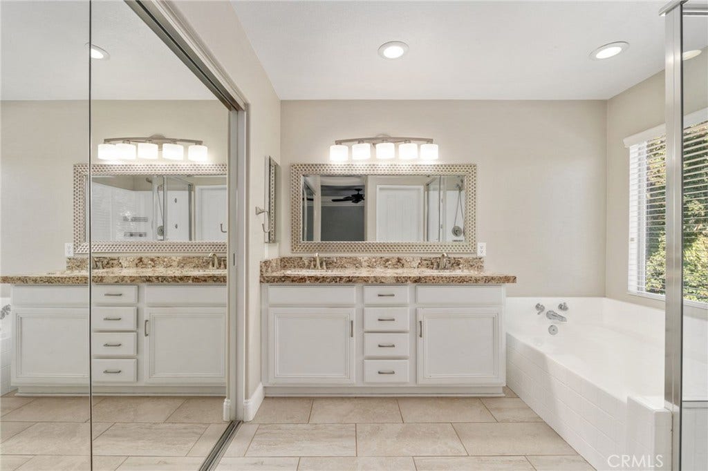 32440 Magenta Court, Temecula, CA 92592 Spacious Primary Bathroom Featuring An Expansive Vanity With Generous Counter Space, Framed Mirror, Relaxing Soaking Tub, And Separate Glass-Enclosed Shower.