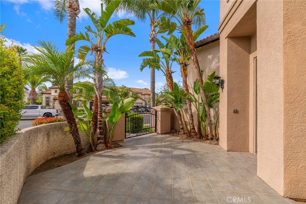 32440 Magenta Court, Temecula, CA 92592 Inviting Front Courtyard Featuring A Spacious Paved Patio, Tropical Landscaping, And A Peaceful Setting For Outdoor Relaxation.