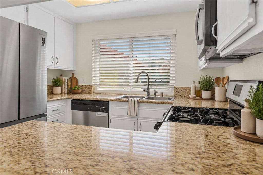 42329 Via Consuelo, Temecula, CA 92592 Another kitchen view highlights the granite countertops, double-basin sink beneath the window, and convenient countertop workspace. Digitally Staged