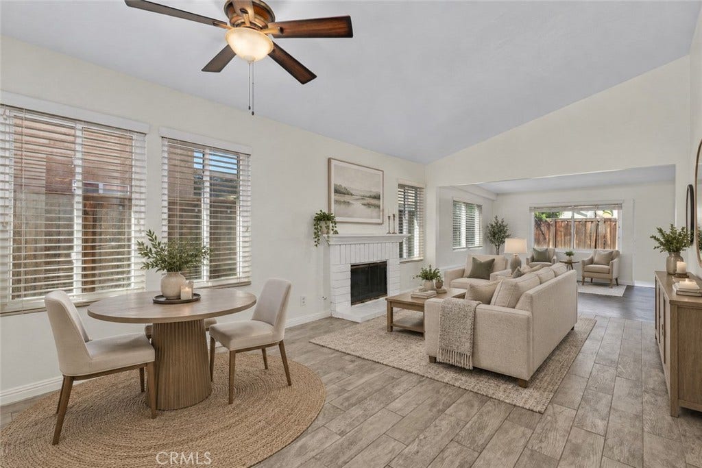 42329 Via Consuelo, Temecula, CA 92592 Bright and inviting living and dining areas featuring wood-look flooring, a cozy fireplace, and an open connection to the enclosed patio. Digitally Staged
