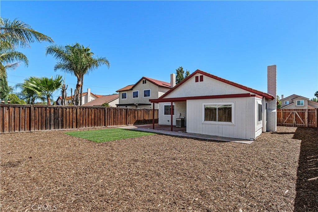 42329 Via Consuelo, Temecula, CA 92592 Another backyard perspective highlights the open outdoor space, perimeter fencing, and mature palm trees beyond the property