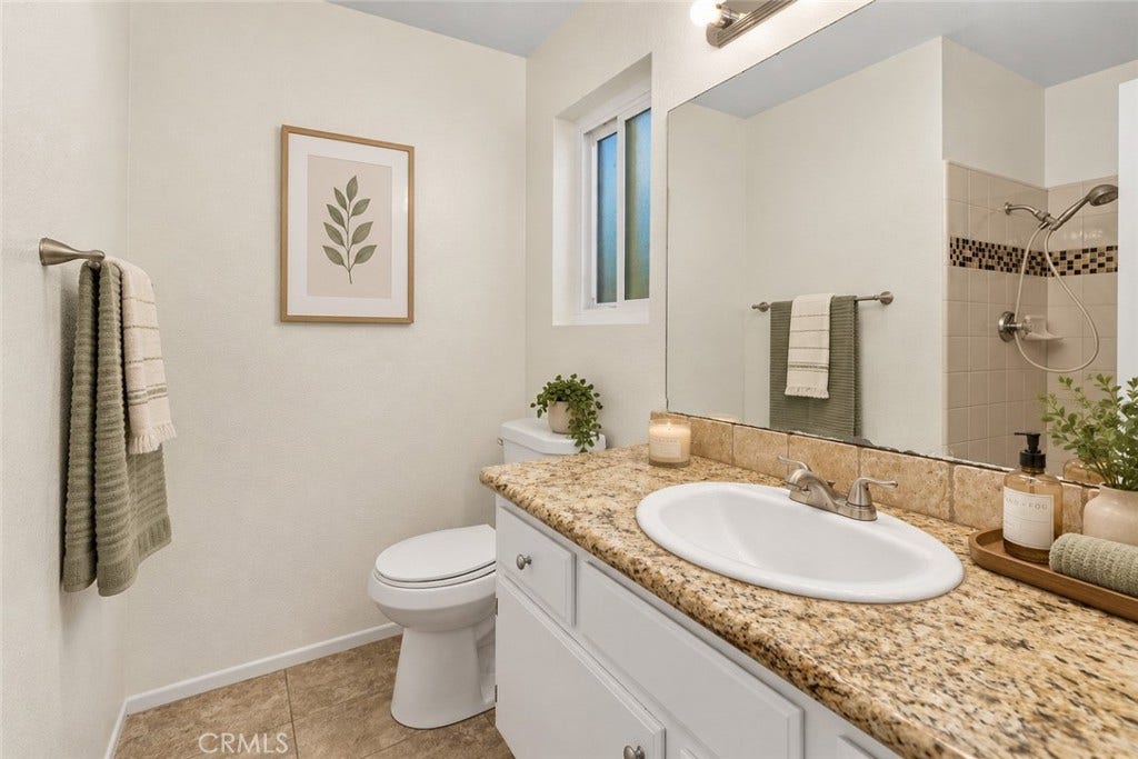 42329 Via Consuelo, Temecula, CA 92592 Primary bathroom featuring a granite-topped vanity, single sink, and tiled shower with decorative mosaic accents. Digitally Staged