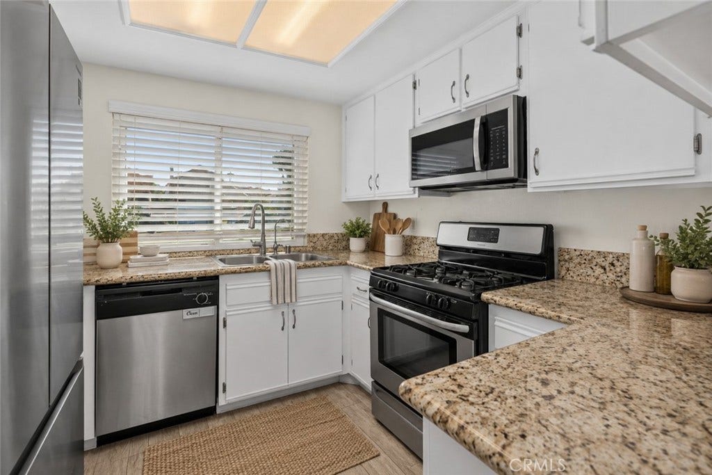 42329 Via Consuelo, Temecula, CA 92592 The kitchen features white cabinetry, granite countertops, stainless steel appliances, and a gas range for everyday cooking. Digitally Staged