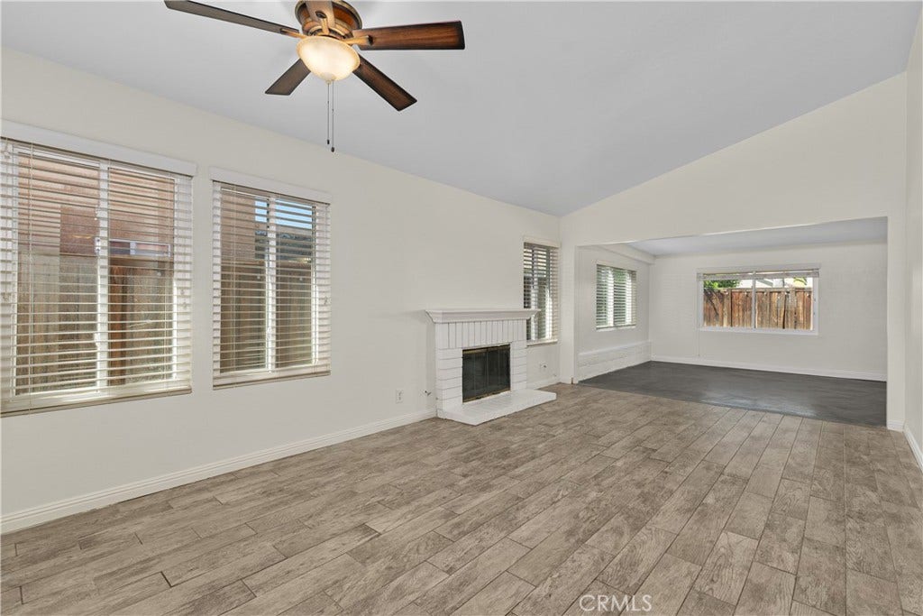 42329 Via Consuelo, Temecula, CA 92592 Bright and inviting living and dining areas featuring wood-look flooring, a cozy fireplace, and an open connection to the enclosed patio.