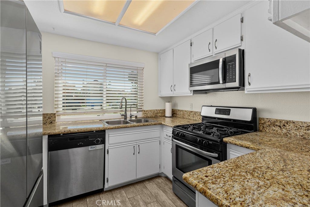 42329 Via Consuelo, Temecula, CA 92592 The kitchen features white cabinetry, granite countertops, stainless steel appliances, and a gas range for everyday cooking.