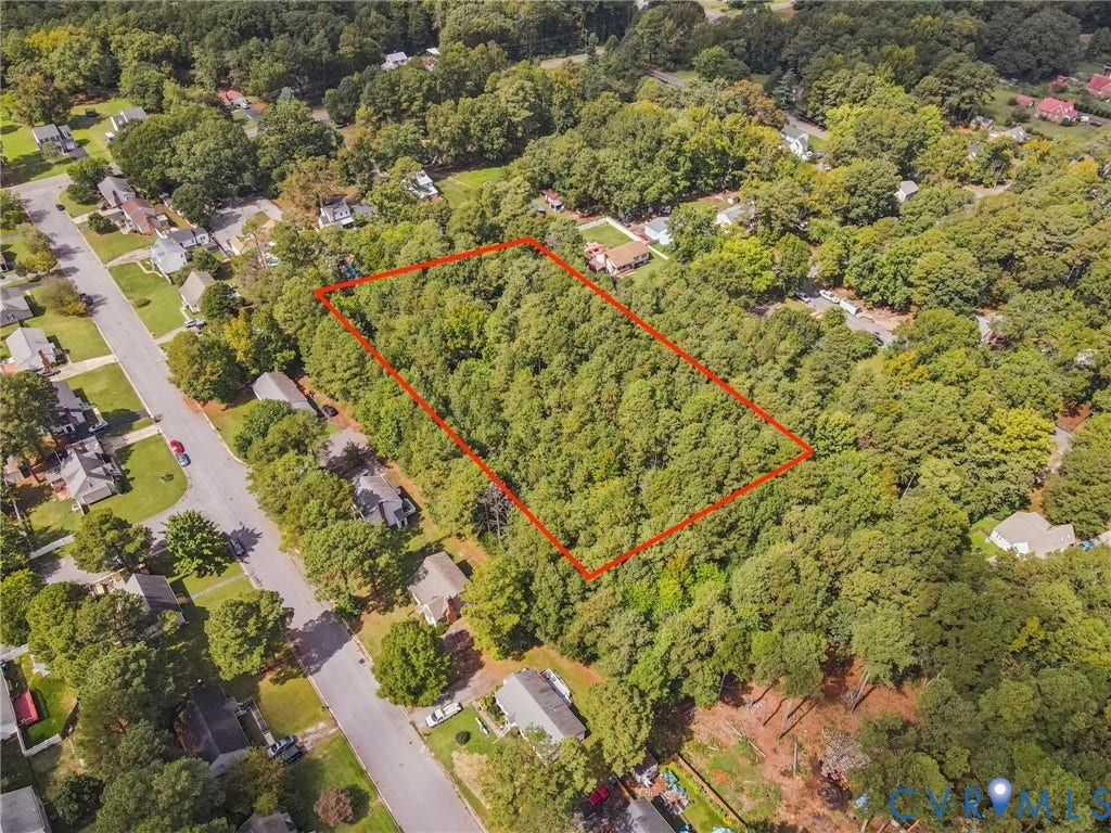 Aerial overview of property's location featuring property boundaries highlighted and a forest