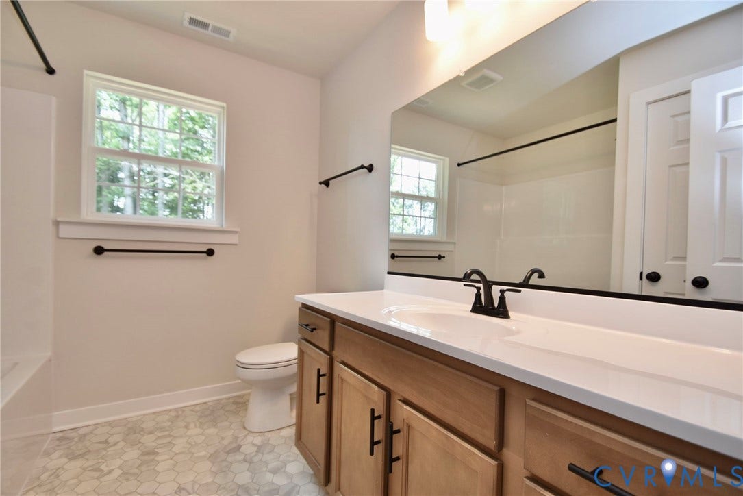 53 Porkchop Court, Louisa, VA 23093 Bathroom featuring a wood-finish vanity with a single sink, light-toned countertop, and hexagonal tile flooring