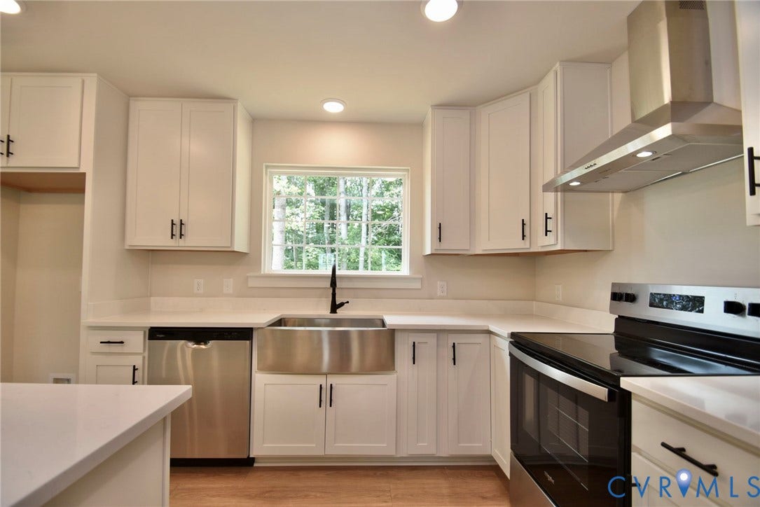 53 Porkchop Court, Louisa, VA 23093 Bright kitchen featuring white cabinetry, light countertops, wood-finish flooring, a stainless-steel farmhouse sink, and stainless-steel appliances