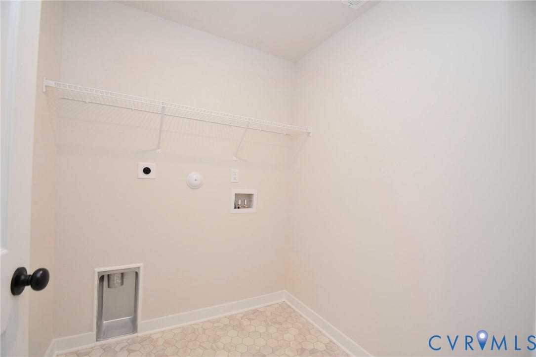 53 Porkchop Court, Louisa, VA 23093 White wire shelving, light-colored hexagon tile flooring, white baseboards, and a black door handle