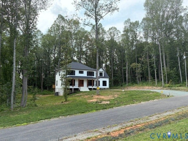 53 Porkchop Court, Louisa, VA 23093 Charming two-story residence with a classic blue and white exterior, situated on a wooded lot with mature birch and pine trees