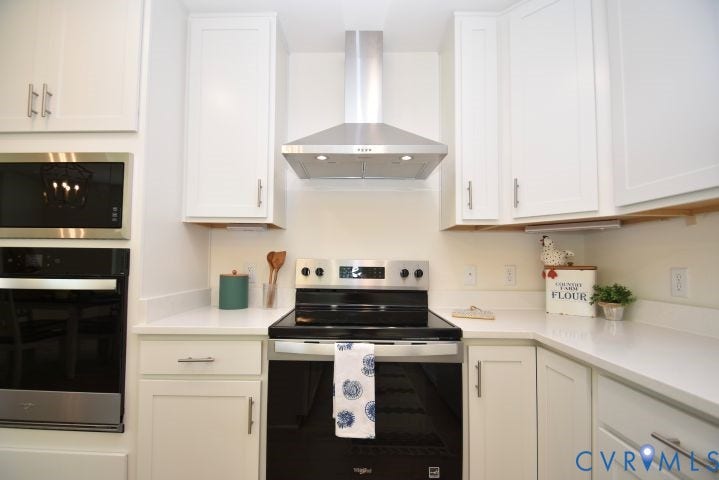 54 Porkchop Court, Louisa, VA 23093 Stainless steel range hood, built-in microwave, wall oven, white cabinetry, and light-toned countertops