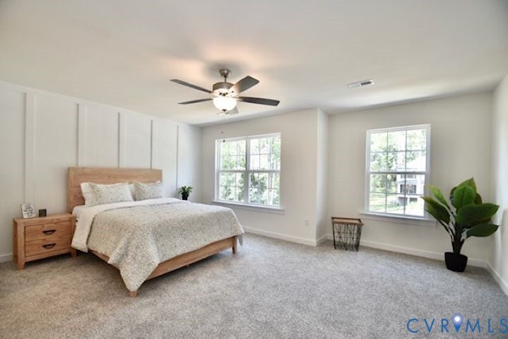 54 Porkchop Court, Louisa, VA 23093 Carpeted flooring, two large windows, ceiling fan with integrated lighting, and a decorative accent wall