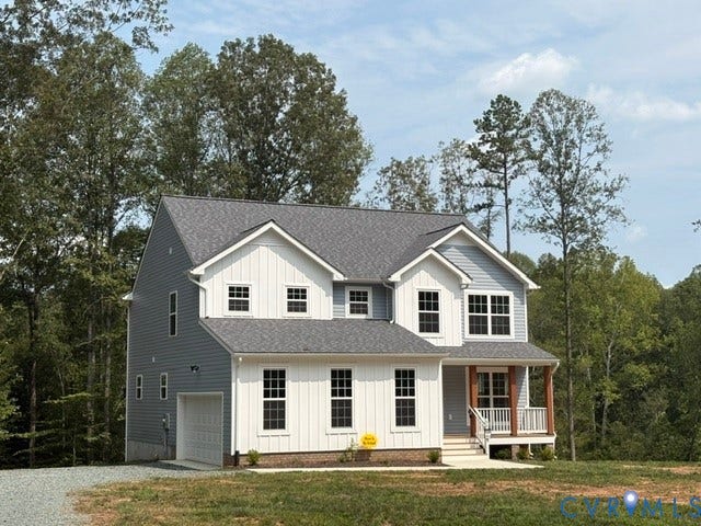 54 Porkchop Court, Louisa, VA 23093 Classic two-story Colonial with white board-and-batten siding, featuring a covered front porch with wood railings, multiple double-hung windows with white trim, and a side-load attached garage