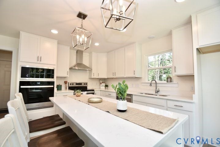 54 Porkchop Court, Louisa, VA 23093 White shaker cabinetry, stainless steel appliances, built-in wall oven and microwave, quartz countertops, and modern pendant lighting