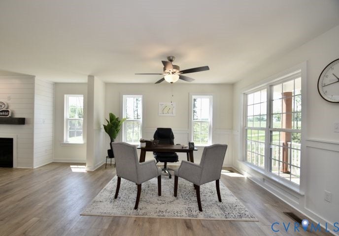 54 Porkchop Court, Louisa, VA 23093 Wood-finish flooring, white shiplap accent wall with fireplace, recessed lighting, ceiling fan, and multiple windows