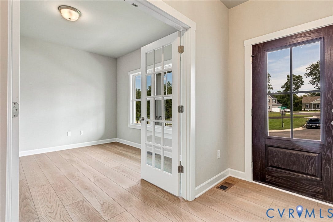 Light wood-finish flooring throughout, framed by white trim