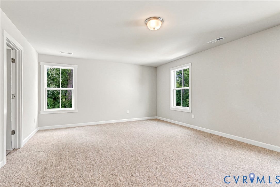 Neutral wall finishes, carpeted flooring, and a flush mount ceiling fixture