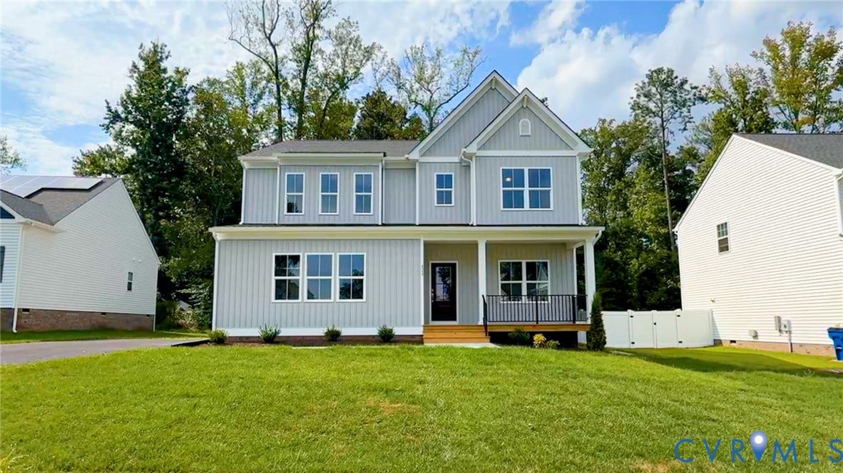 Two-story residence featuring light gray vertical and horizontal siding, a covered front porch with a black railing, and a dark entry door