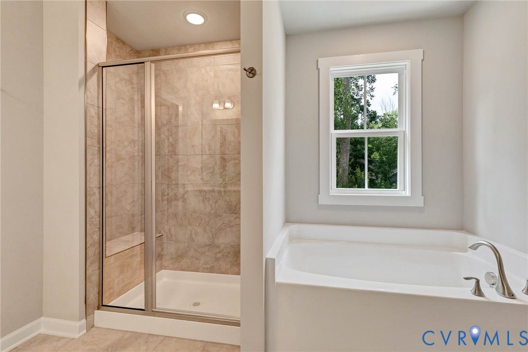 Full-size shower with glass enclosure, integrated bench, and overhead lighting