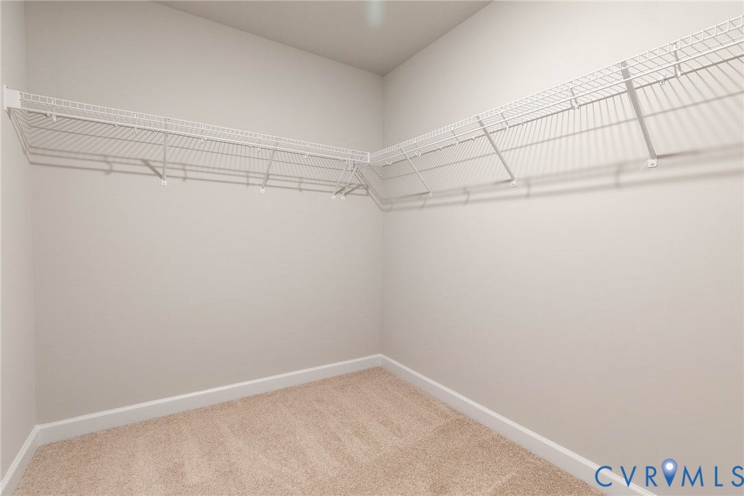 Carpet flooring, white wire shelving, neutral wall paint