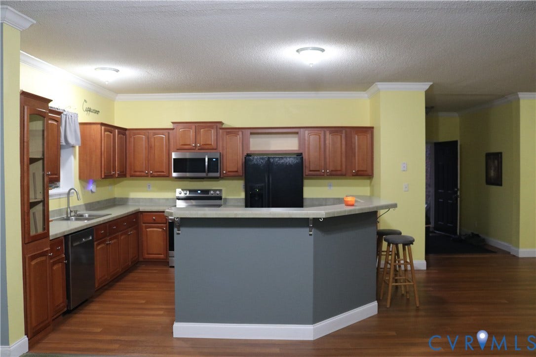 128 Quarry, Quarry, Cumberland, VA 23040 Kitchen with black appliances, dark wood-style floors, a textured ceiling, light countertops, and ornamental molding