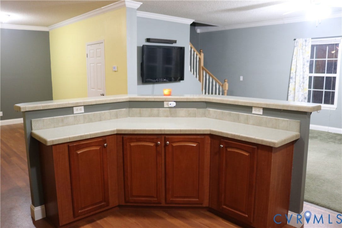 128 Quarry, Quarry, Cumberland, VA 23040 Kitchen featuring ornamental molding, light countertops, a textured ceiling, dark wood-type flooring, and an island with sink