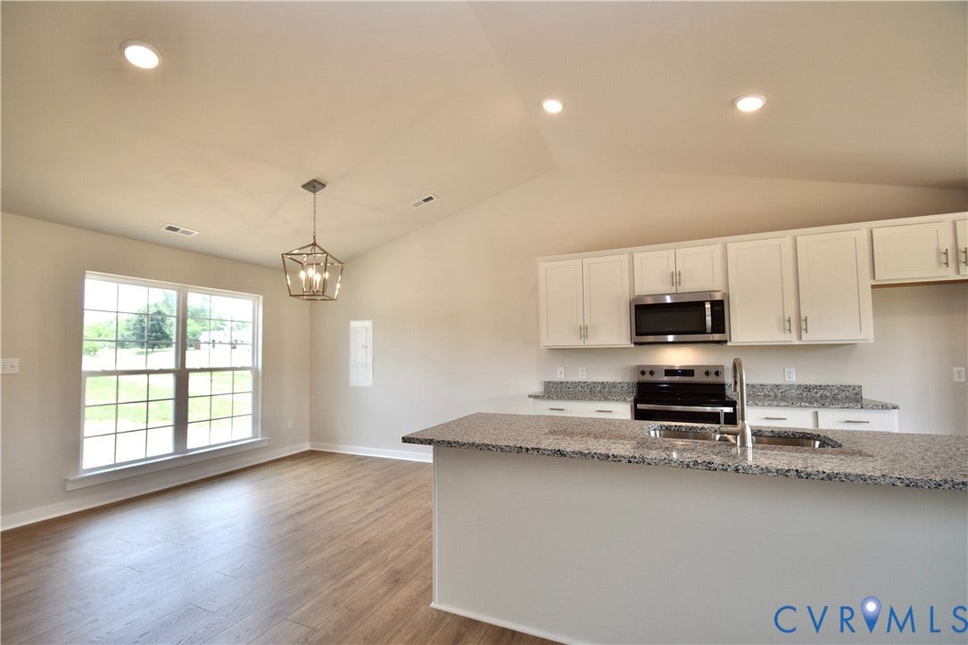 Open-concept kitchen and dining area with vaulted ceilings
