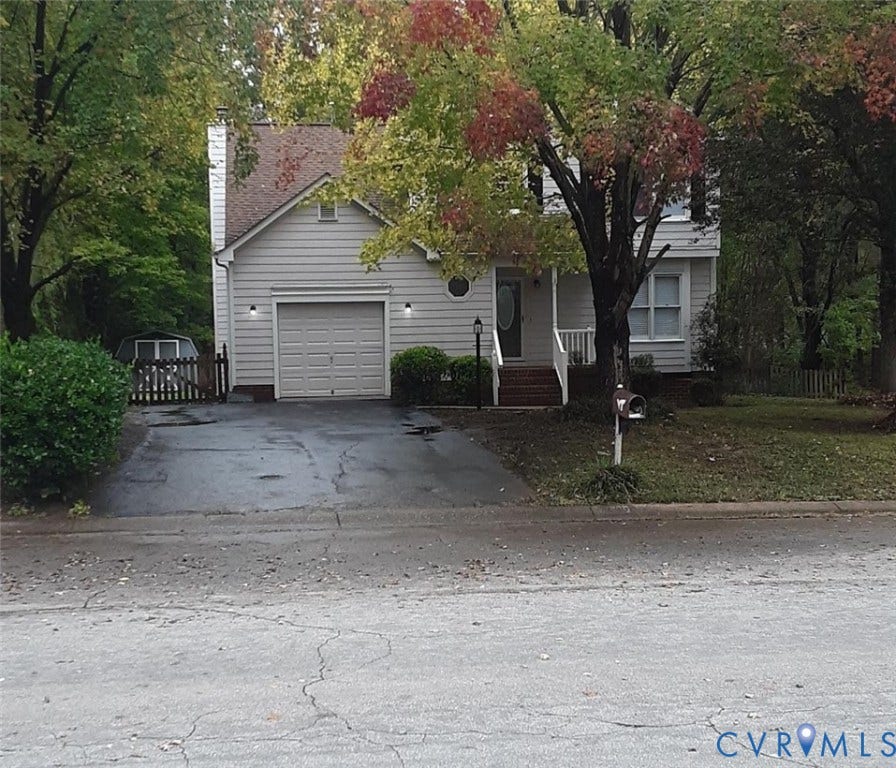 5104 Highberry Woods Road, Richmond, VA 23112 View of property hidden behind natural elements with driveway, an attached garage, and a chimney