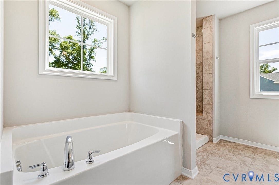 11105 Somerset Bluff Court, Somerset Hills, Glen Allen, VA 23059 White soaking tub with chrome fixtures, tiled shower, and light-toned floor tiling