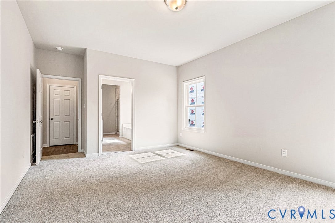 Spacious room featuring neutral carpeting and light-toned walls