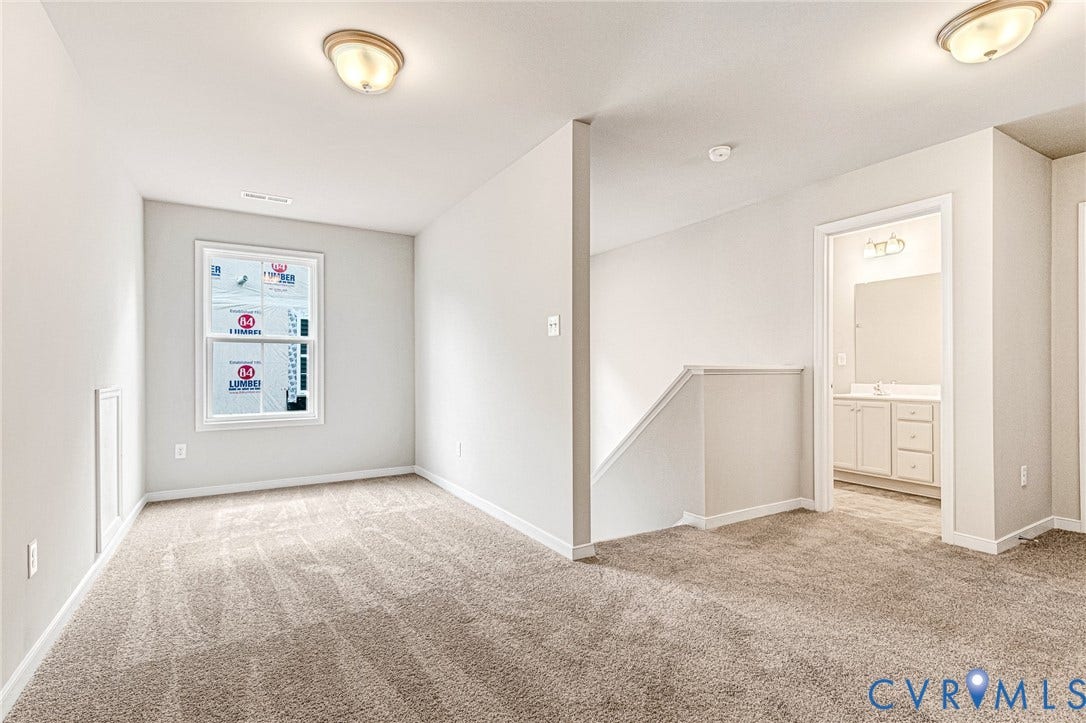 Carpeted room with a single window and recessed wall paneling