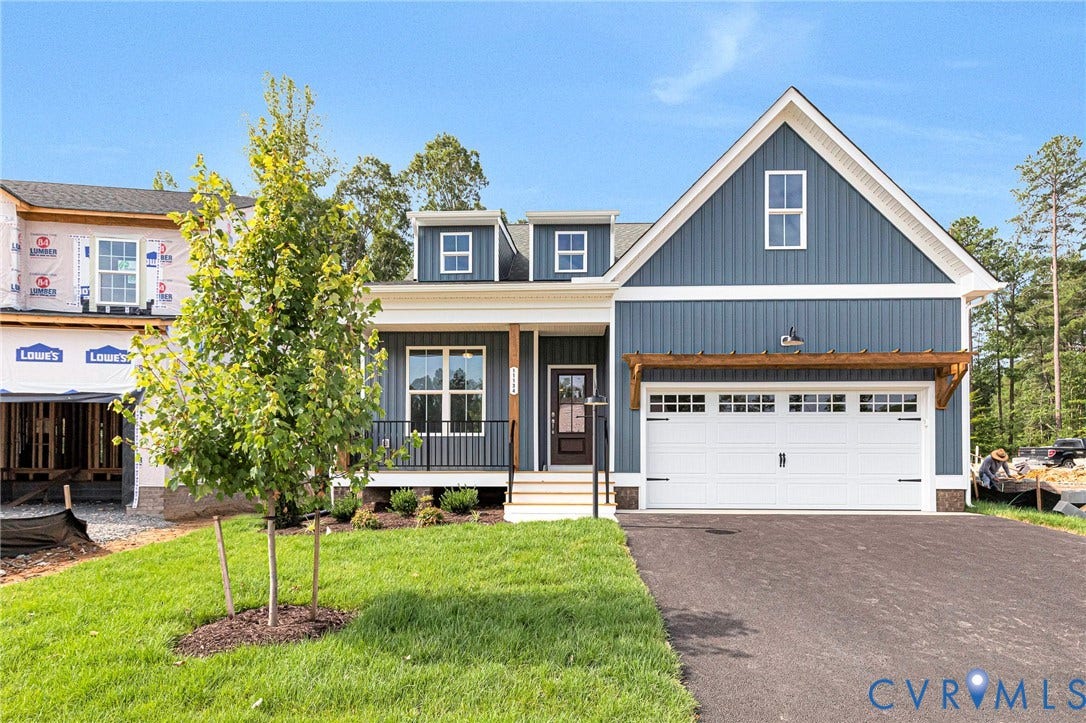 Contemporary home with blue vertical siding, white trim, and a prominent front-facing gable