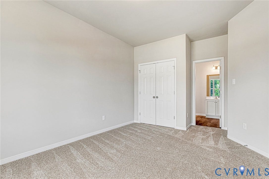 Neutral tone wall paint, light-colored carpet flooring, white bi-fold closet doors, and recessed lighting in the doorway