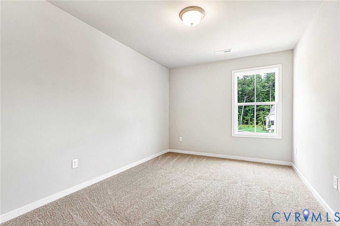 Carpeted room featuring a single window, overhead lighting, and light-toned walls