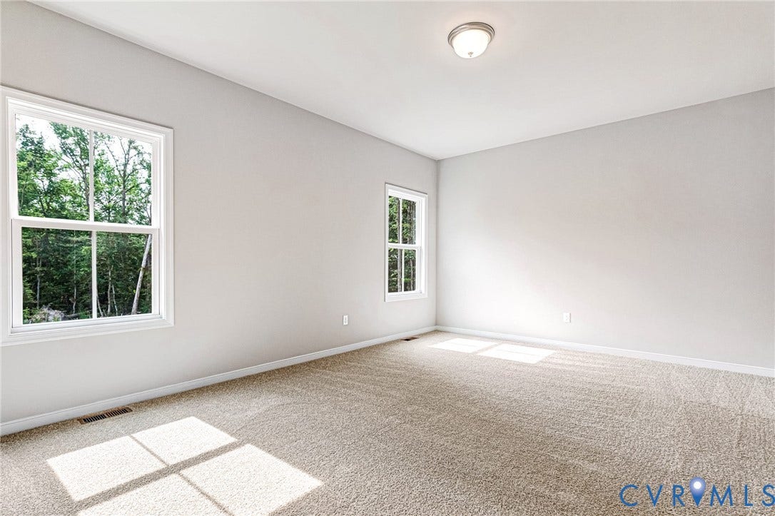 Spacious room featuring neutral carpeting and light-toned walls