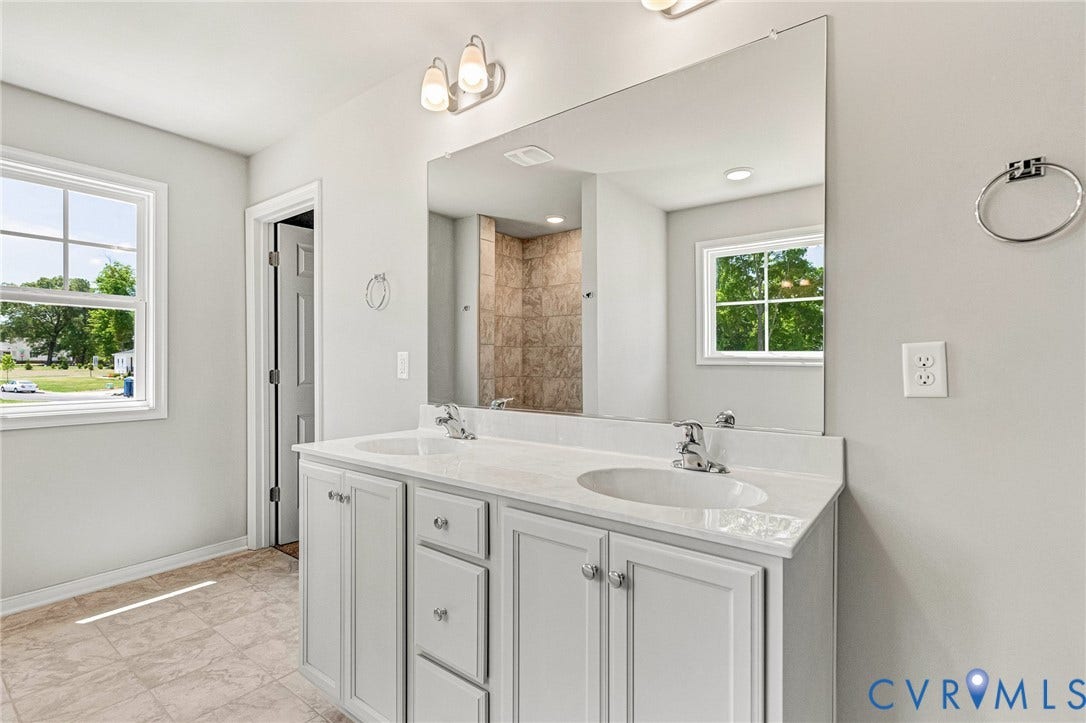 12606 Poplar Village Place, Poplar Village, Chester, VA 23831 Dual vanity with white cabinetry, integrated sinks, chrome fixtures, and a large wall-mounted mirror