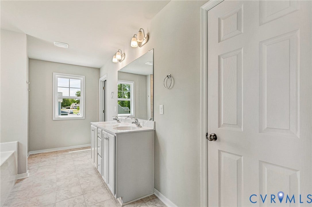 12606 Poplar Village Place, Poplar Village, Chester, VA 23831 Double vanity with white cabinetry and integrated sinks, large mirror, and overhead lighting