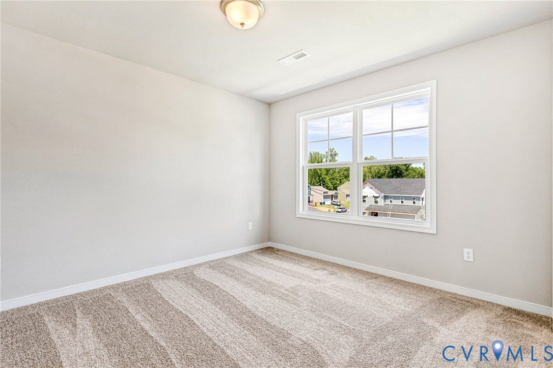 12606 Poplar Village Place, Poplar Village, Chester, VA 23831 Room featuring a large window with white trim, light gray walls, and patterned carpeting