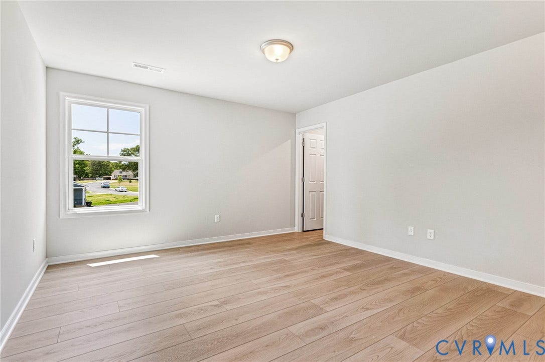 12606 Poplar Village Place, Poplar Village, Chester, VA 23831 Bright room featuring wood-finish flooring, a double-paned window, white baseboards, and a flush-mount ceiling light fixture