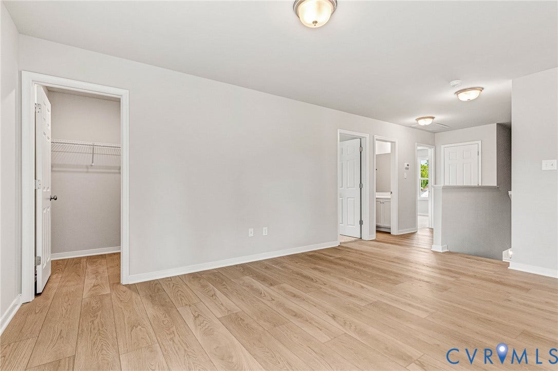 12606 Poplar Village Place, Poplar Village, Chester, VA 23831 Open room featuring wood-finish flooring, white baseboards, and neutral wall paint