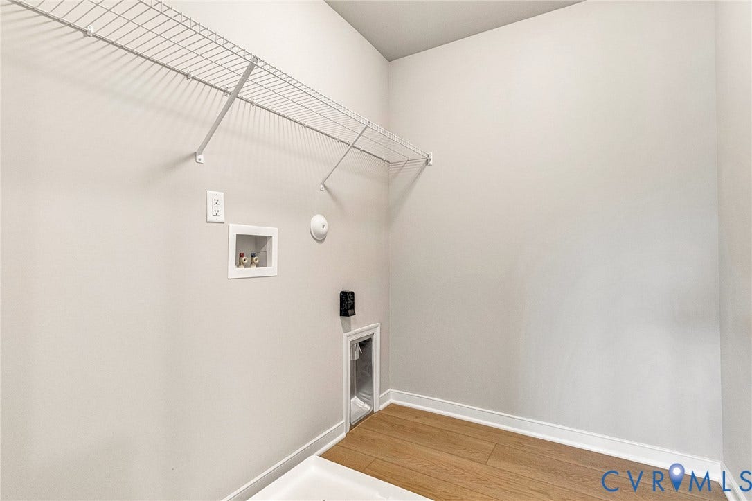 12606 Poplar Village Place, Poplar Village, Chester, VA 23831 Dedicated utility space featuring wood-finish flooring, white wire shelving, wall-mounted electrical outlets, and plumbing hookups