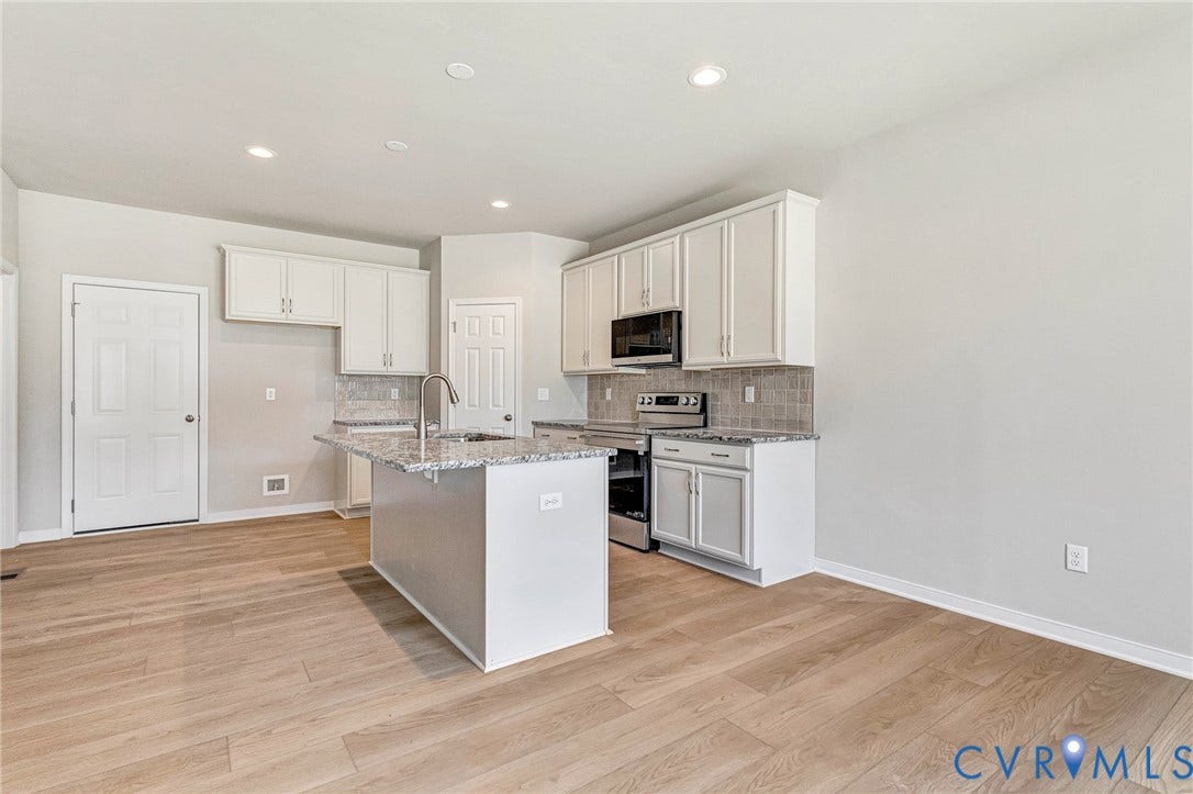 12606 Poplar Village Place, Poplar Village, Chester, VA 23831 Contemporary kitchen featuring light wood-finish flooring, white cabinetry, a central island with a sink and a gooseneck faucet, stainless steel appliances, and recessed lighting