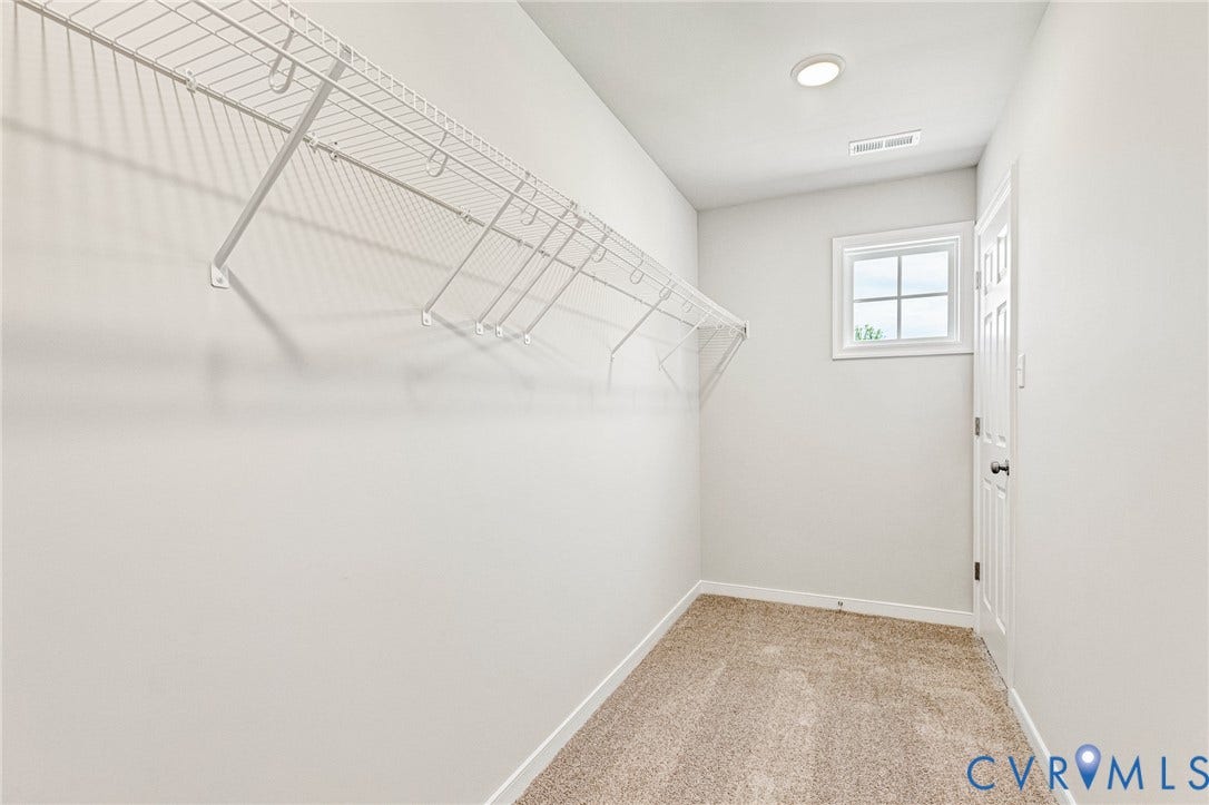 12606 Poplar Village Place, Poplar Village, Chester, VA 23831 Spacious walk-in closet featuring light beige carpet flooring, built-in wire shelving, recessed ceiling lighting, and a single pane window with white trim